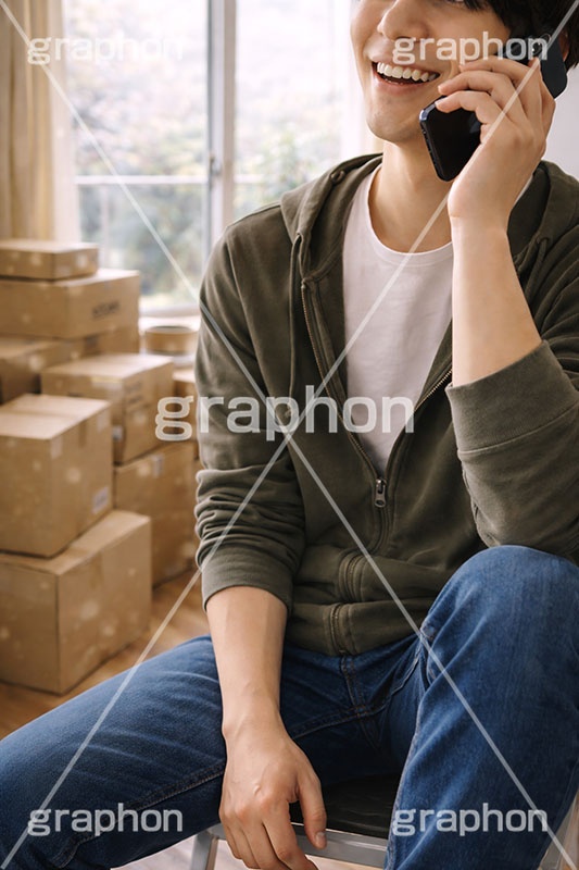 新生活,引っ越し,引越し,一人暮らし,就職,入学,卒業,荷物,荷造り,荷ほどき,荷解き,片付け,片づけ,作業,電話,通話,連絡,スマホ,スマートフォン,親,実家,段ボール,ダンボール,ワンルーム,アパート,人物,男性,男,AI生成素材